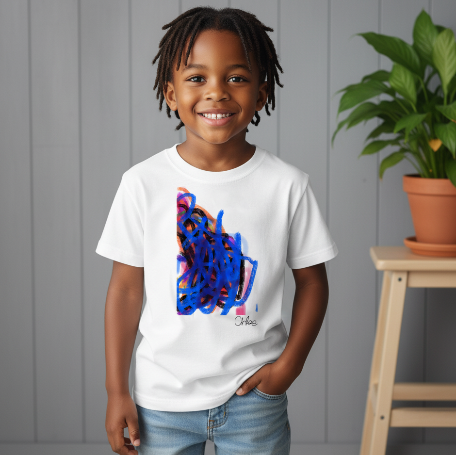 Child wearing a white t-shirt with colorful abstract design, standing in front of a gray wall with a plant.